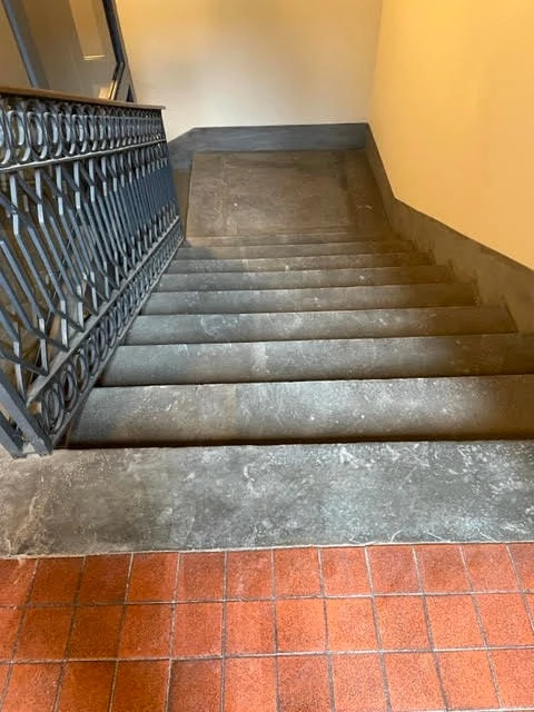 Scala condominiale in pietra con ringhiera in ferro